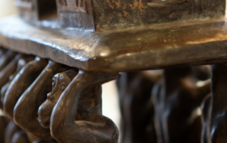 Close-up van het bronzen beeld ‘Hommage’, de wisseltrofee van de Willy van Heumenprijs, met daarboven de tekst ‘Young TPI wint Willy van Heumenprijs!’ en het logo van Proefdiervrij.