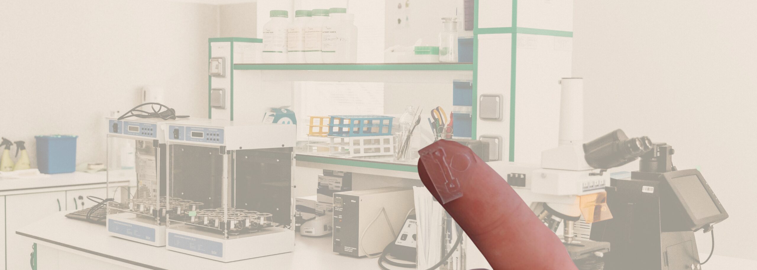 lab met op de voorgrond een vinger met mini-chip erop